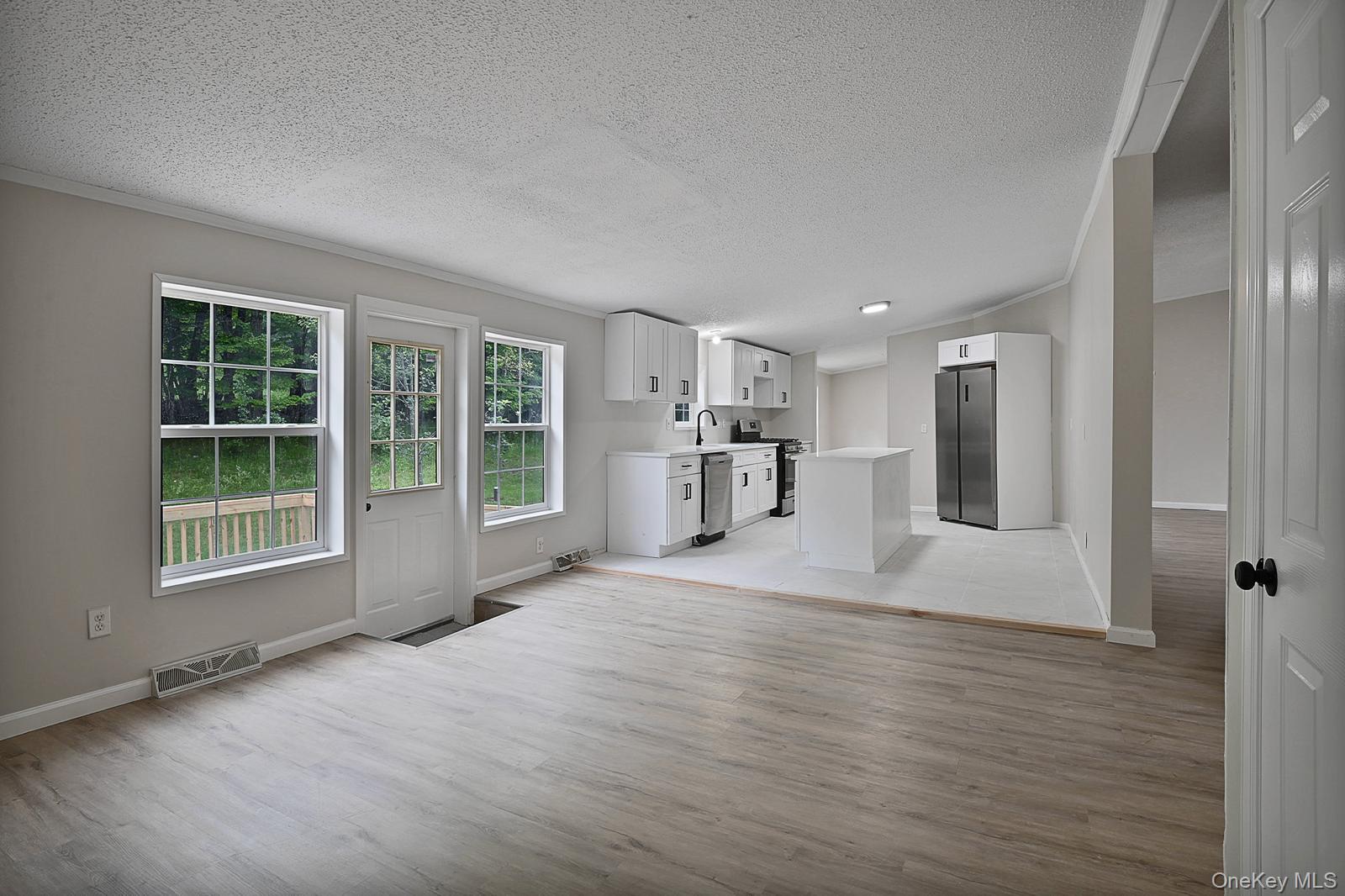 386 Airport Road Liberty, NY 12754 - Photo 3 of 21 a view of an empty room with a window and wooden floor