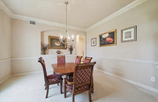 a view of staircase with lots of frames on wall and a chandelier