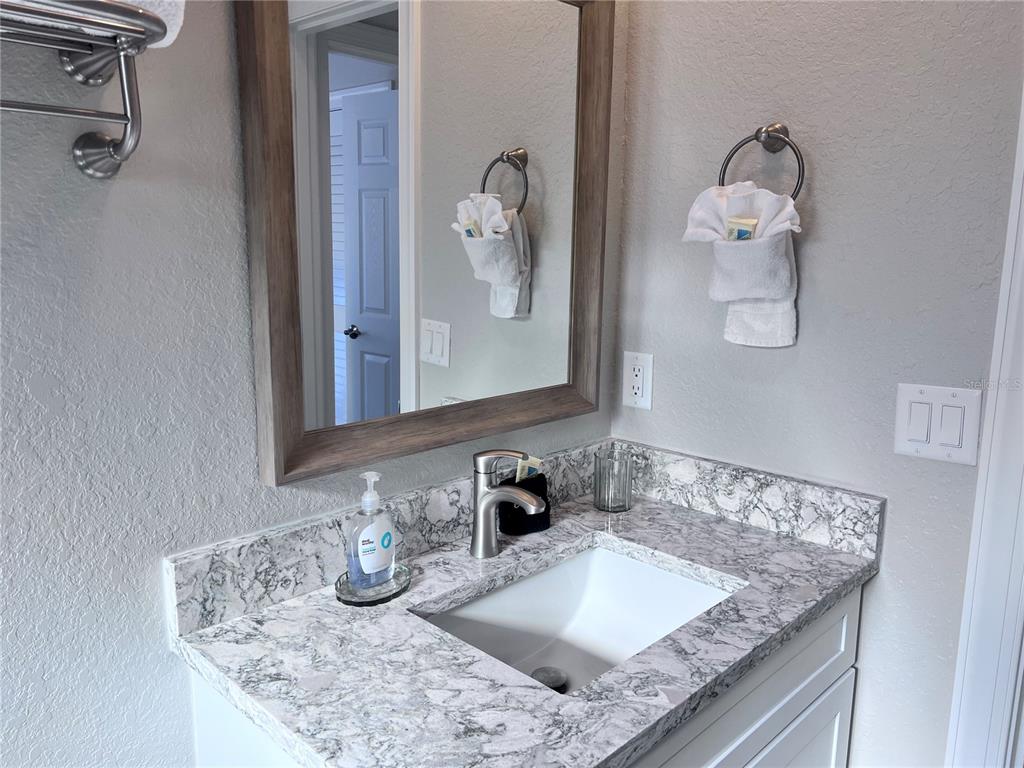 6154 Midnight Pass Road, Unit A11 Sarasota, FL 34242 - Photo 15 of 22 a bathroom with a granite countertop sink and a mirror