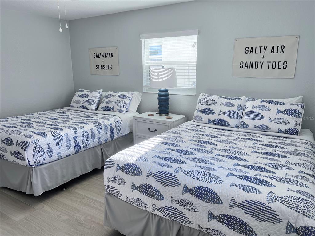 6154 Midnight Pass Road, Unit A11 Sarasota, FL 34242 - Photo 17 of 22 a bedroom with two beds and painting on the wall