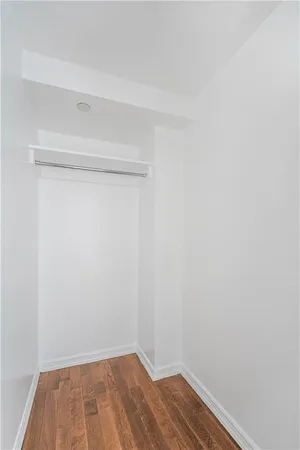 a view of a small space with wooden floor and a window