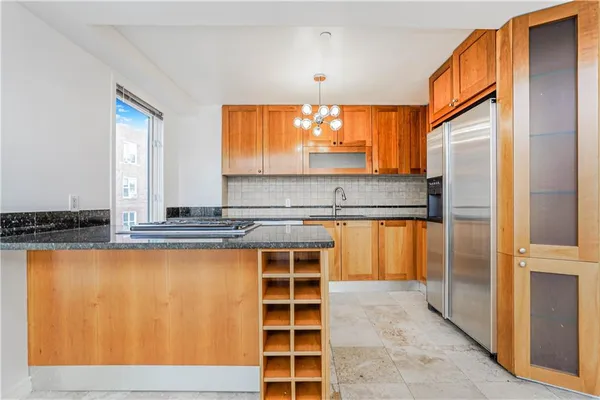 a view of kitchen with stainless steel appliances granite countertop a sink and a refrigerator