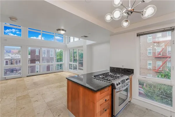 a kitchen that has a lot of stainless steel appliances granite countertop a stove and a large window