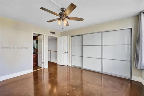 a view of a livingroom with wooden floor and a ceiling fan