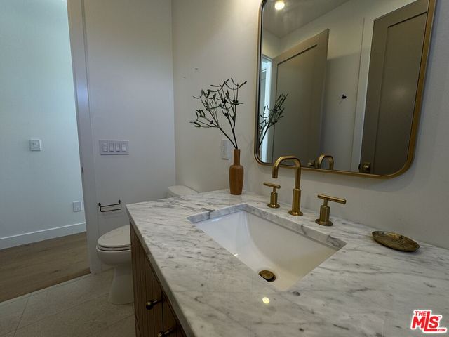 a bathroom with a granite countertop sink and a mirror