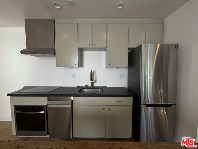 a kitchen with a sink a refrigerator and cabinets