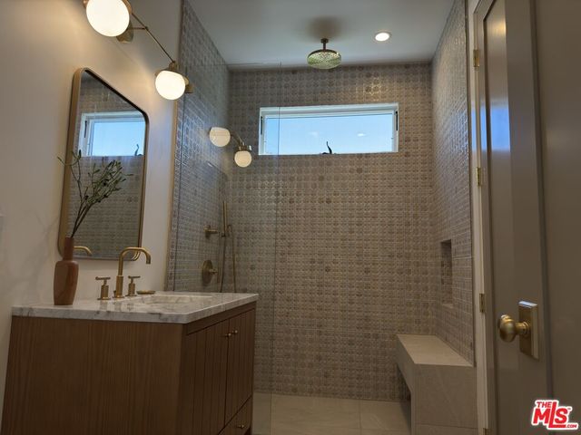 a bathroom with a sink mirror and shower