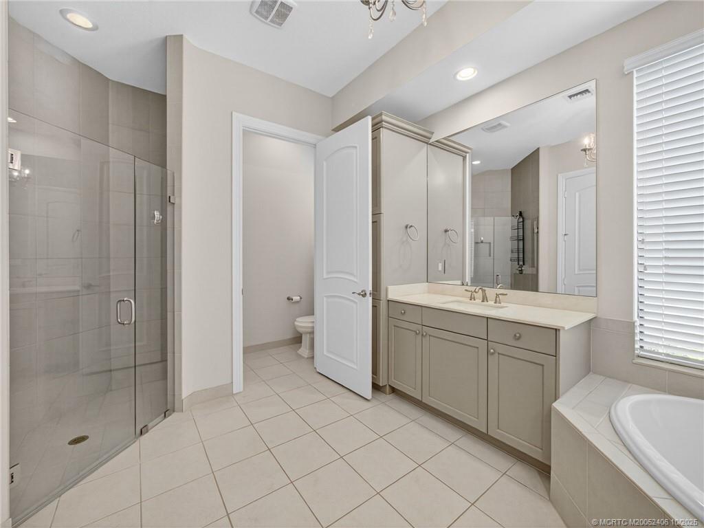 600 Southeast Fascino Circle Port St. Lucie, FL 34984 - Photo 15 of 22 a bathroom with a double vanity sink toilet and shower