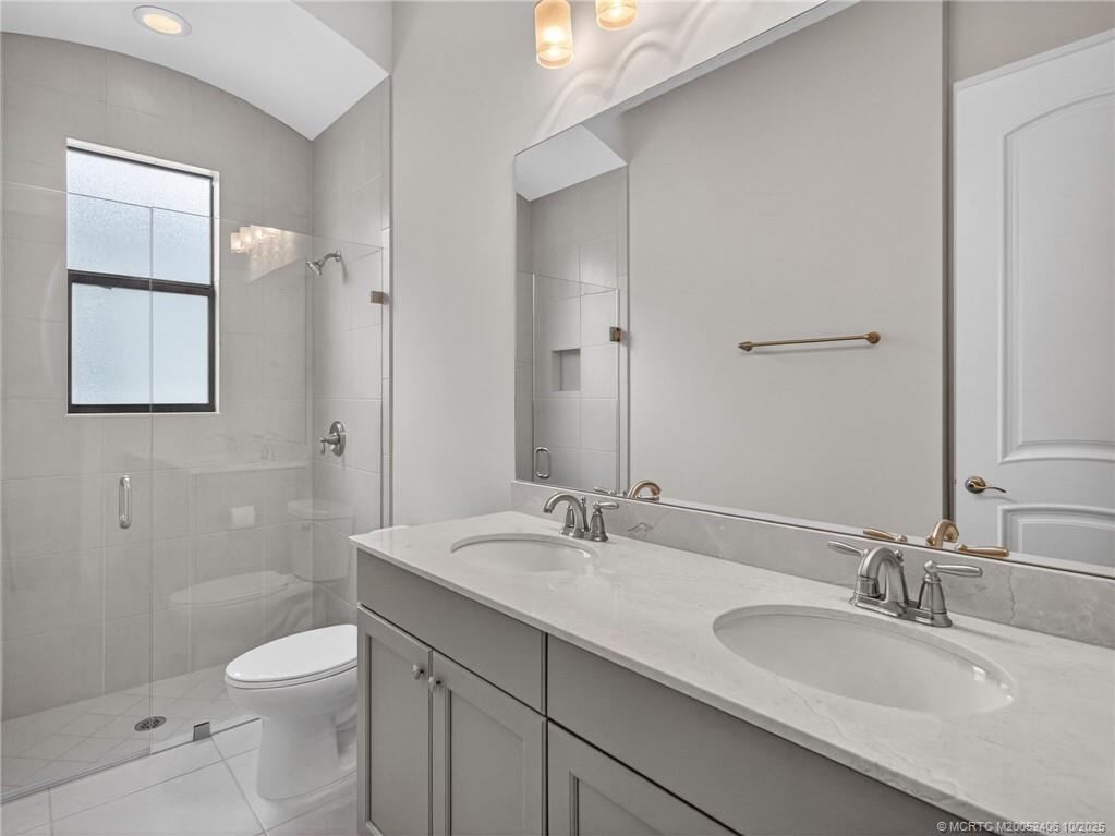 600 Southeast Fascino Circle Port St. Lucie, FL 34984 - Photo 18 of 22 a bathroom with a granite countertop toilet sink and mirror