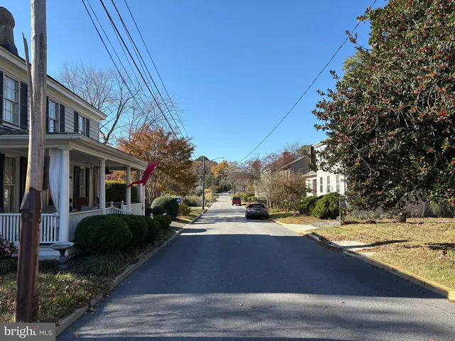 a view of multiple houses with yard and green space