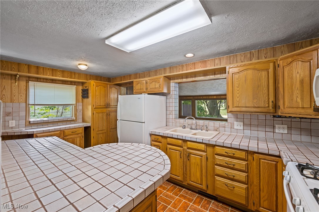 718 Fairwood Road Akron, OH 44319 - Photo 5 of 15 Kitchen featuring sink, tile countertops, and a healthy amount of sunlight