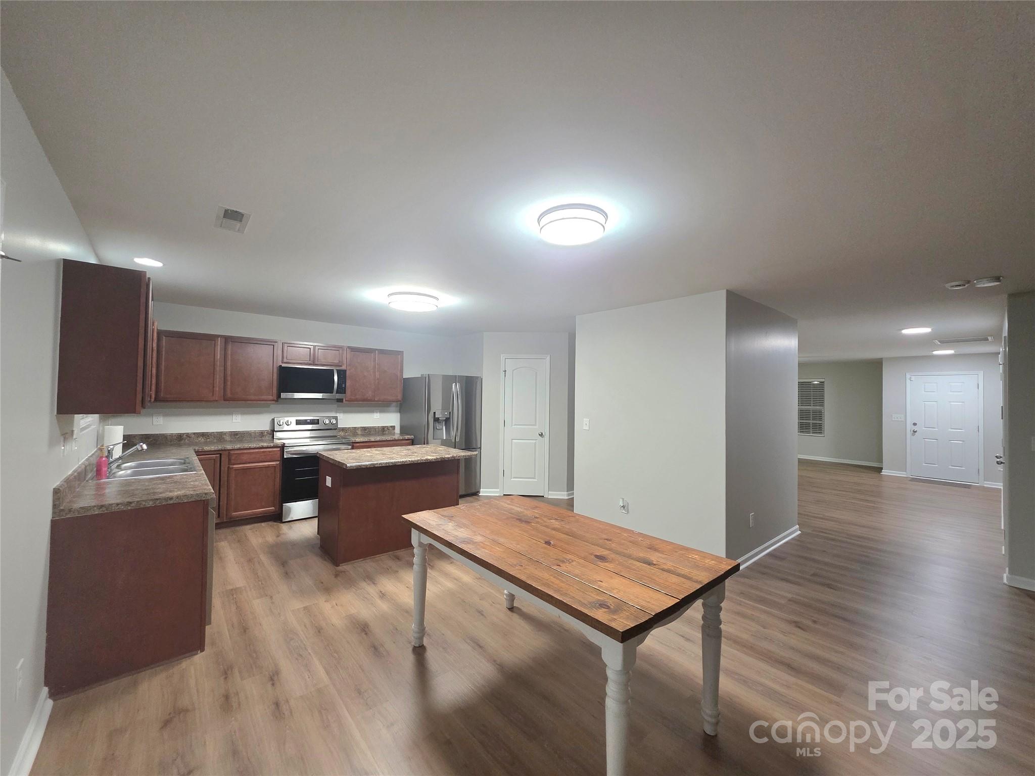 1047 Mackey Court Gastonia, NC 28056 - Photo 29 of 30 a room with kitchen island a sink dishwasher a stove and a refrigerator with wooden floor