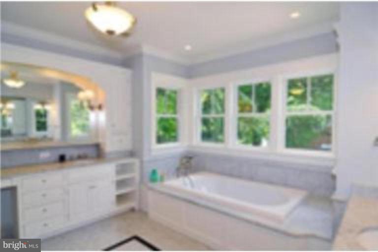 7816 Maple Ridge Road Bethesda, MD 20814 - Photo 12 of 16 a bathroom with a bathtub a sink and a window