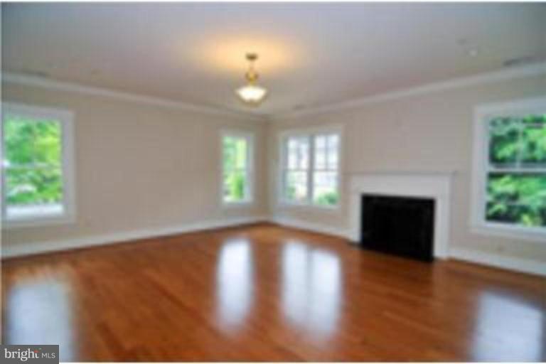 7816 Maple Ridge Road Bethesda, MD 20814 - Photo 14 of 16 an empty room with wooden floor fireplace and windows