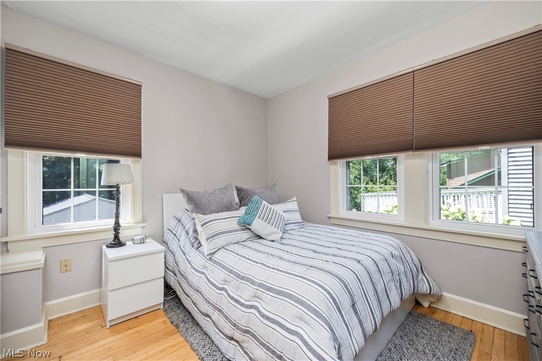 26019 Lake Road Bay Village, OH 44140 - Photo 24 of 40 Bedroom featuring wood-finish flooring, two large windows with pleated shades, and light-toned wall paint