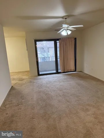 a view of a livingroom with a chandelier fan and window