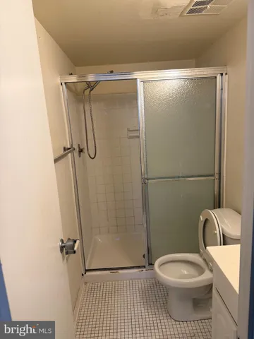 an empty room with a chandelier fan and windows