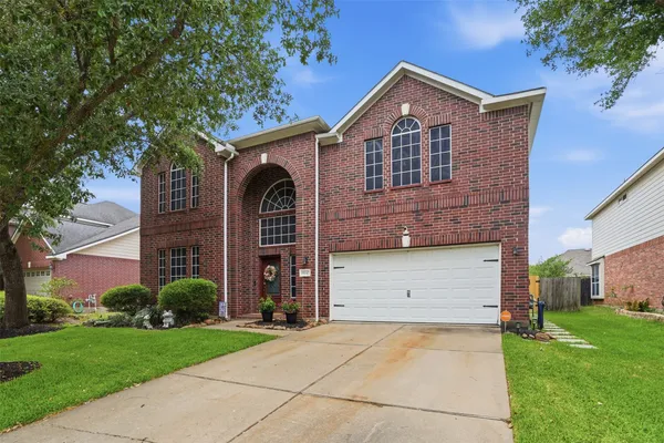 a front view of a house with a garden and plants