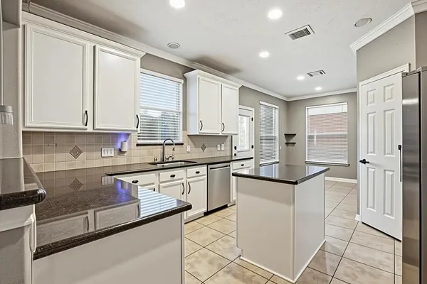 a kitchen with a sink stainless steel appliances cabinets and a counter top space
