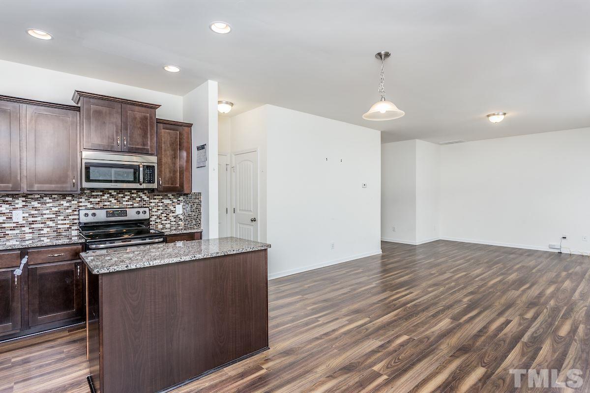 1417 Lombar Street Raleigh, NC 27610 - Photo 11 of 19 a kitchen with stainless steel appliances granite countertop a stove a sink and a refrigerator