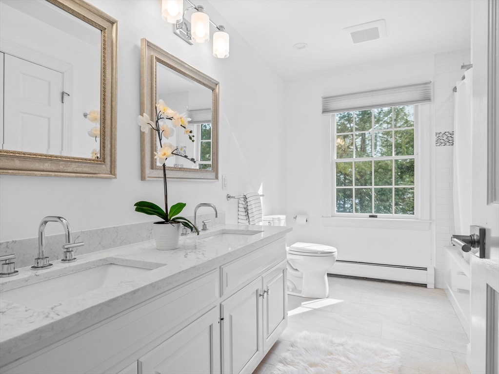 10 Livingston Road Wellesley, MA 02482 - Photo 25 of 36 a bathroom with a double vanity sink a mirror and a window