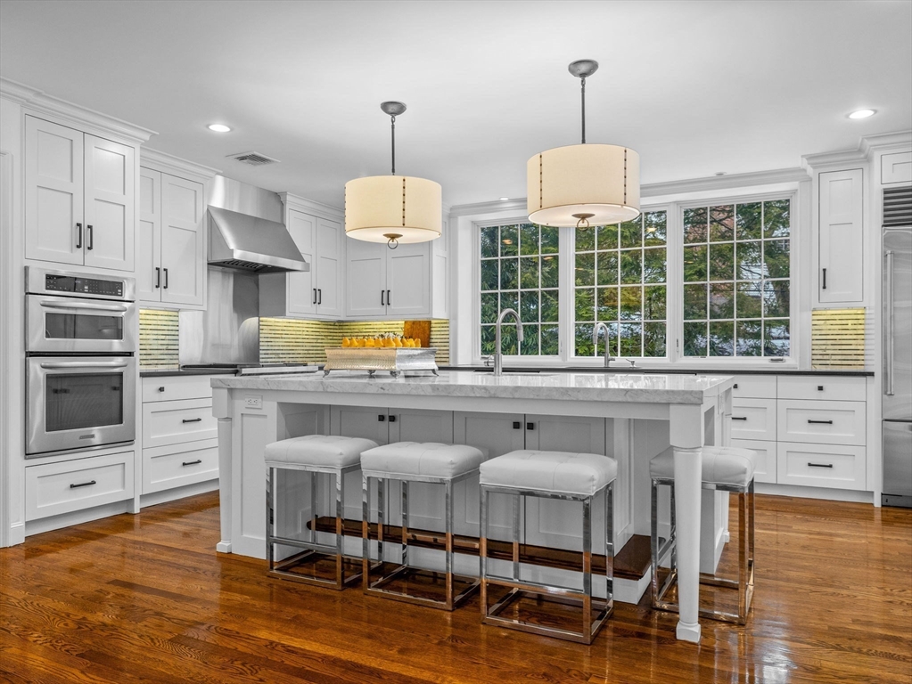 10 Livingston Road Wellesley, MA 02482 - Photo 9 of 36 a kitchen with stainless steel appliances kitchen island granite countertop a stove a refrigerator and a dining table with wooden floors