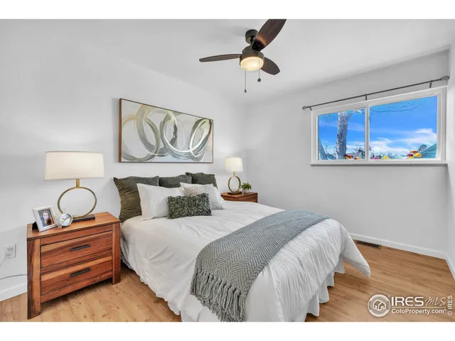 a bedroom with a bed and painting on the wall