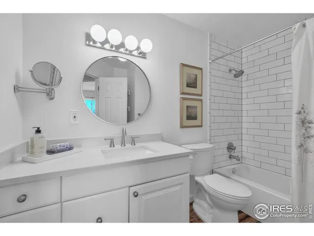 a bathroom with a granite countertop sink mirror and toilet