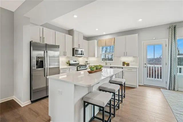a kitchen with white cabinets and sink