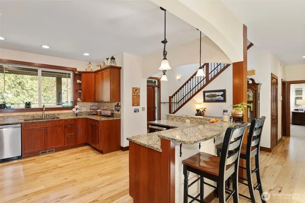 a kitchen with stainless steel appliances granite countertop wooden cabinets and a stove top oven
