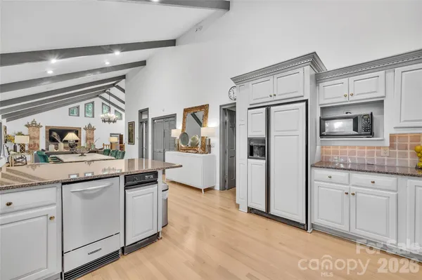 a kitchen with granite countertop white cabinets and white appliances