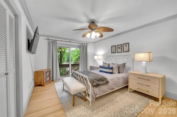a bedroom with a bed and a flat tv screen on the dresser