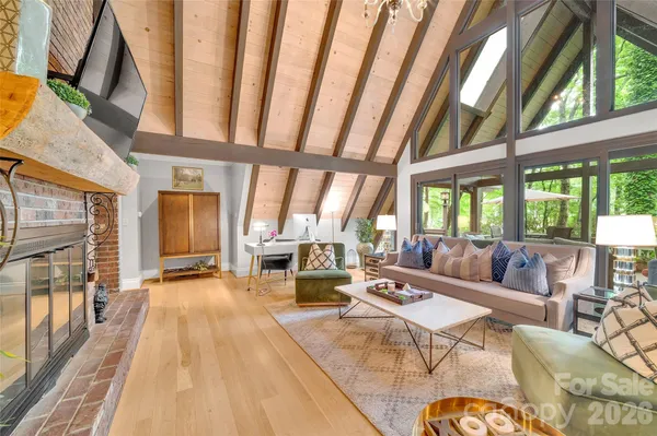 a dining room with wooden floor a chandelier a wooden table and chairs