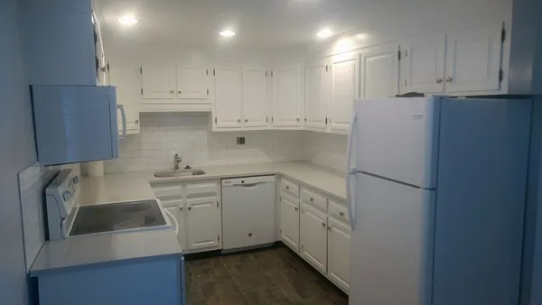 a kitchen with stainless steel appliances white cabinets and a sink