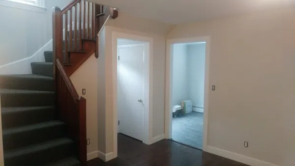 a view of hallway with stairs and wooden floor