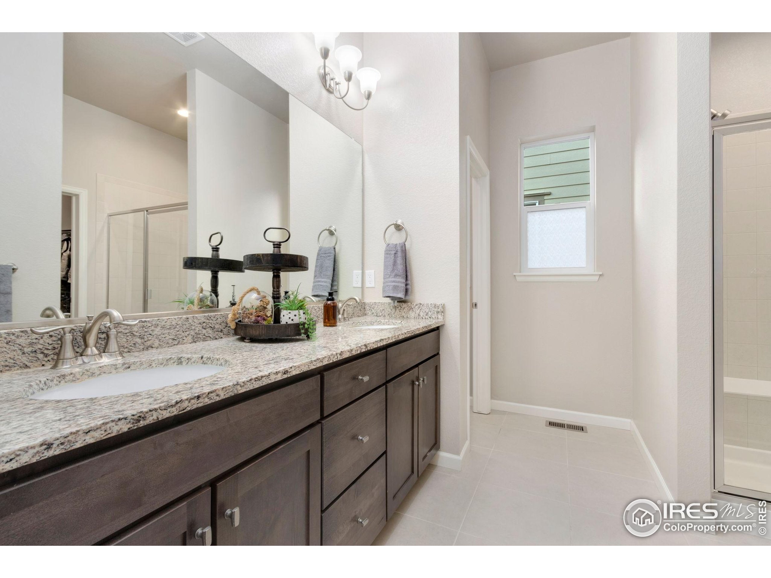 719 Wagon Bend Road Berthoud, CO 80513 - Photo 19 of 40 a bathroom with a granite countertop sink and a mirror