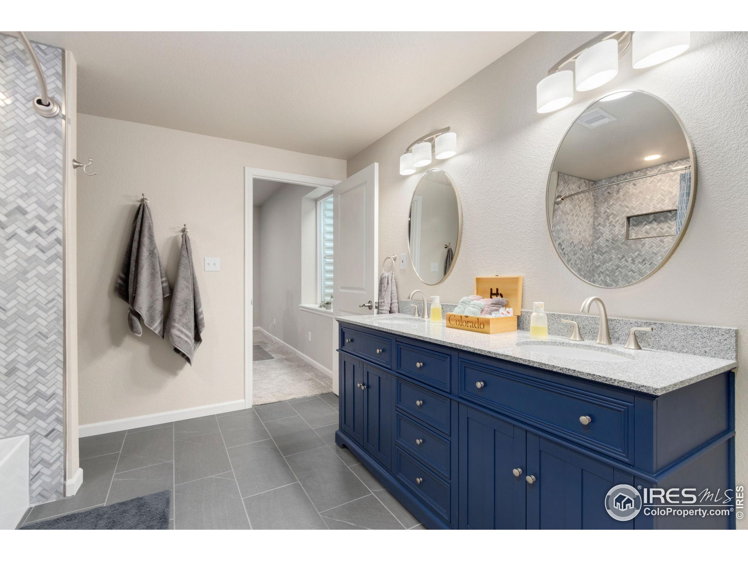 719 Wagon Bend Road Berthoud, CO 80513 - Photo 30 of 40 a bathroom with a double vanity sink and mirror
