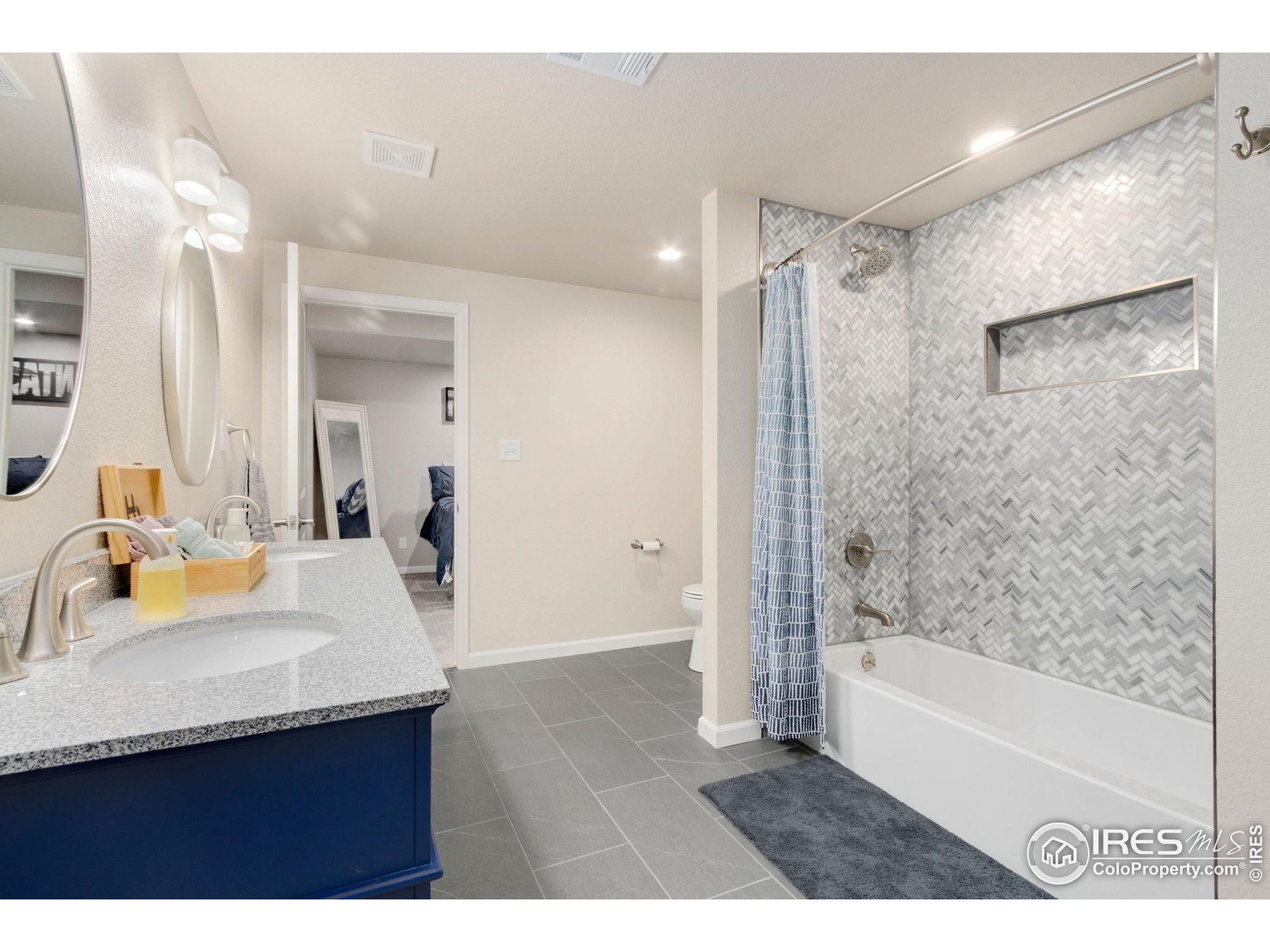 719 Wagon Bend Road Berthoud, CO 80513 - Photo 31 of 40 a bathroom with a granite countertop sink mirror bathtub and shower