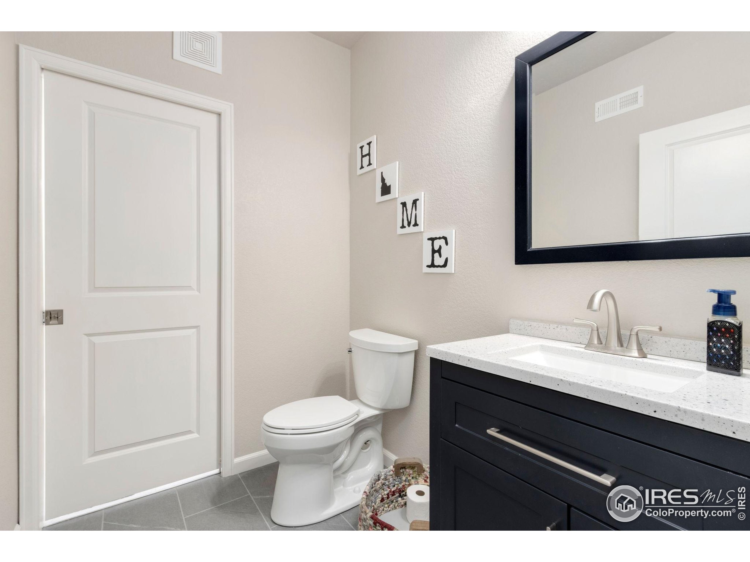 719 Wagon Bend Road Berthoud, CO 80513 - Photo 34 of 40 a bathroom with a granite countertop sink a toilet and a mirror