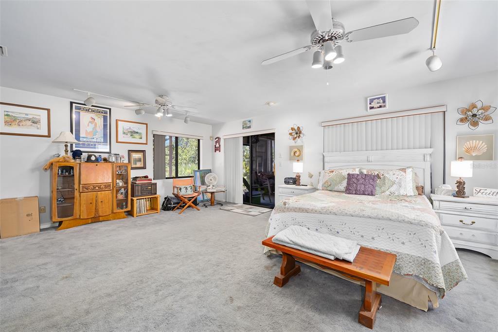 14 Marsh Court Ponce Inlet, FL 32127 - Photo 21 of 64 a spacious bedroom with a bed and a chandelier