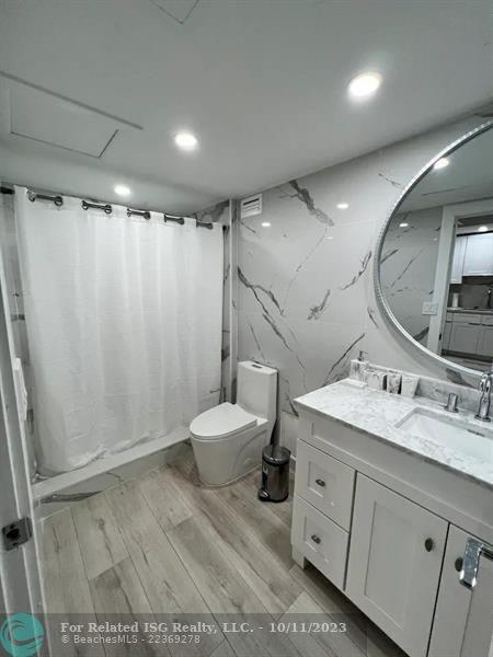 2301 Collins Avenue, Unit 327 Miami Beach, FL 33139 - Photo 8 of 11 a large bathroom with a sink a toilet and shower