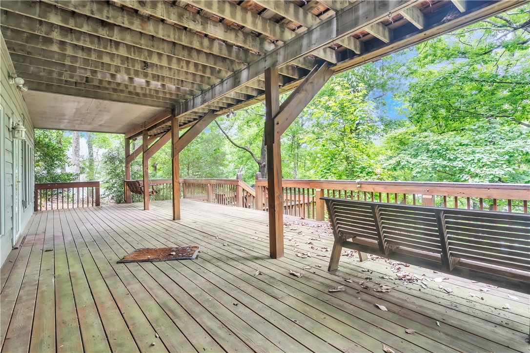 149 Inlet Pointe Drive Anderson, SC 29625 - Photo 28 of 43 A spacious wooden deck extends into a verdant landscape, offering an inviting outdoor retreat.