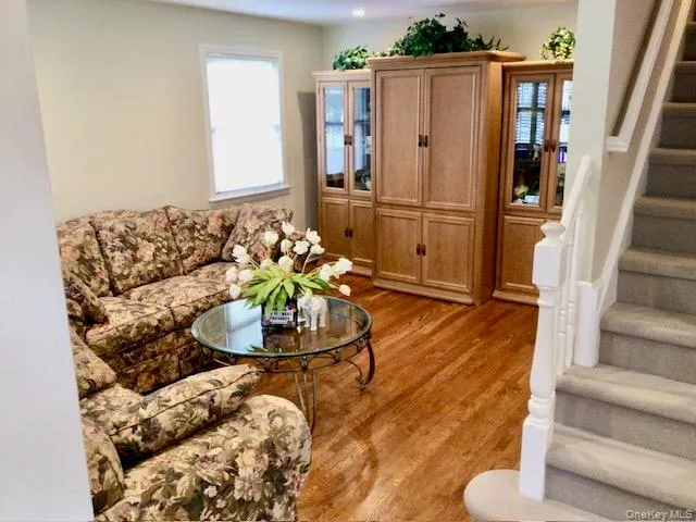 a living room with furniture and a refrigerator