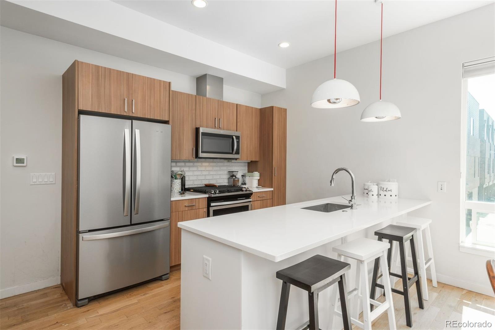 910 West 40th Avenue Denver, CO 80211 - Photo 4 of 33 a kitchen with a refrigerator a stove a sink and a refrigerator
