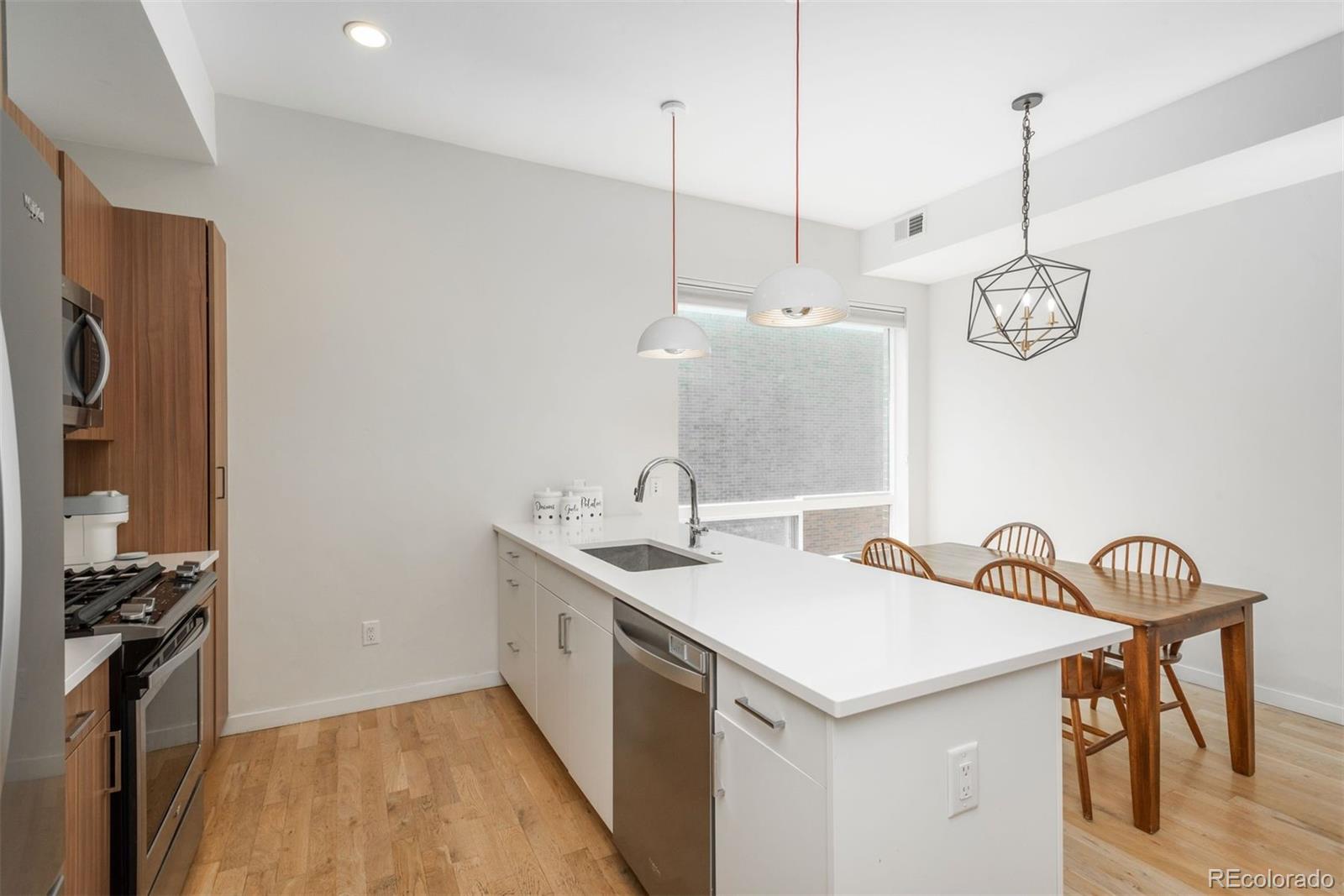 910 West 40th Avenue Denver, CO 80211 - Photo 6 of 33 a kitchen that has a sink a stove and a wooden floor