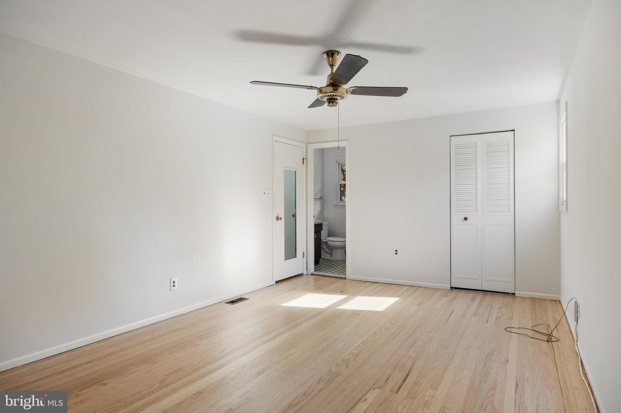 602 Wellfleet Road Cinnaminson, NJ 08077 - Photo 30 of 35 an empty room with wooden floor a ceiling fan and windows