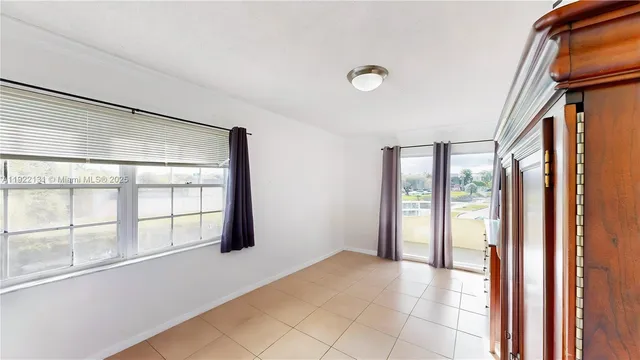 a bedroom with a balcony a bed and a large window