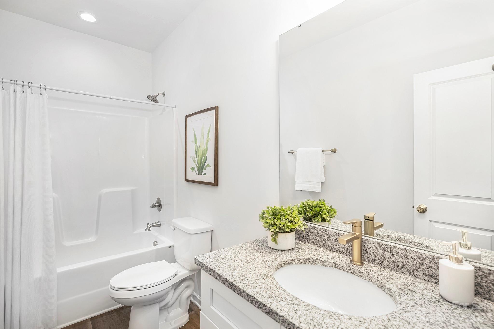 8725 Mt Holly Road Charlotte, NC 28214 - Photo 17 of 19 a bathroom with a granite countertop sink mirror vanity and toilet