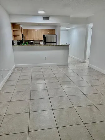 a view of a livingroom with kitchen space and window
