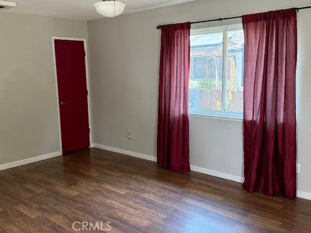 a view of a room with wooden floor and a window